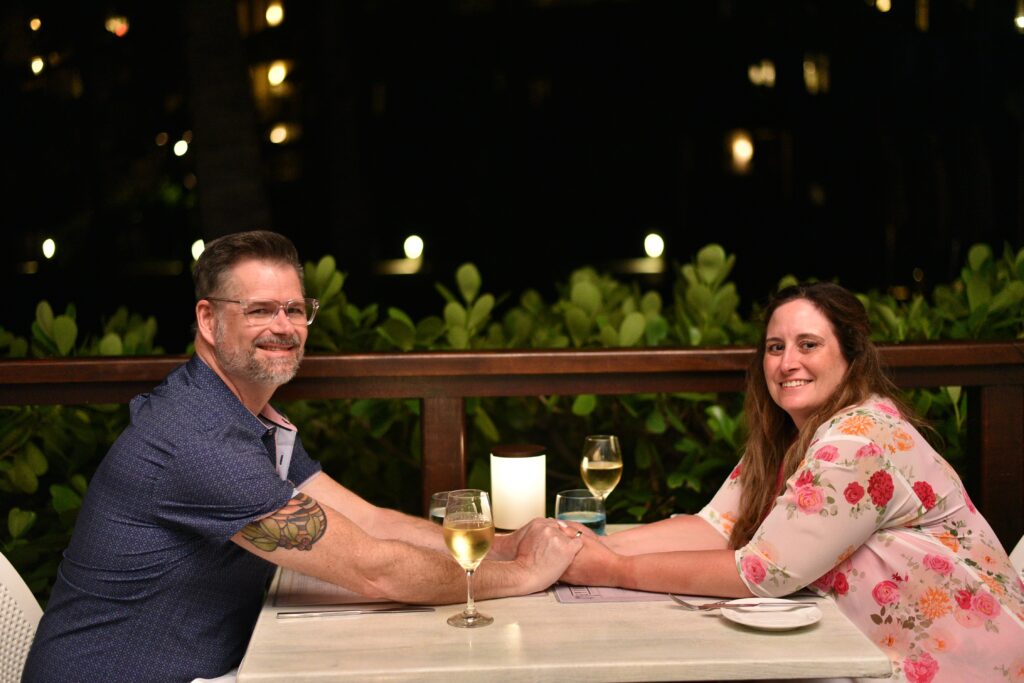 Two lovers holding hands across a dinner table in Grenada