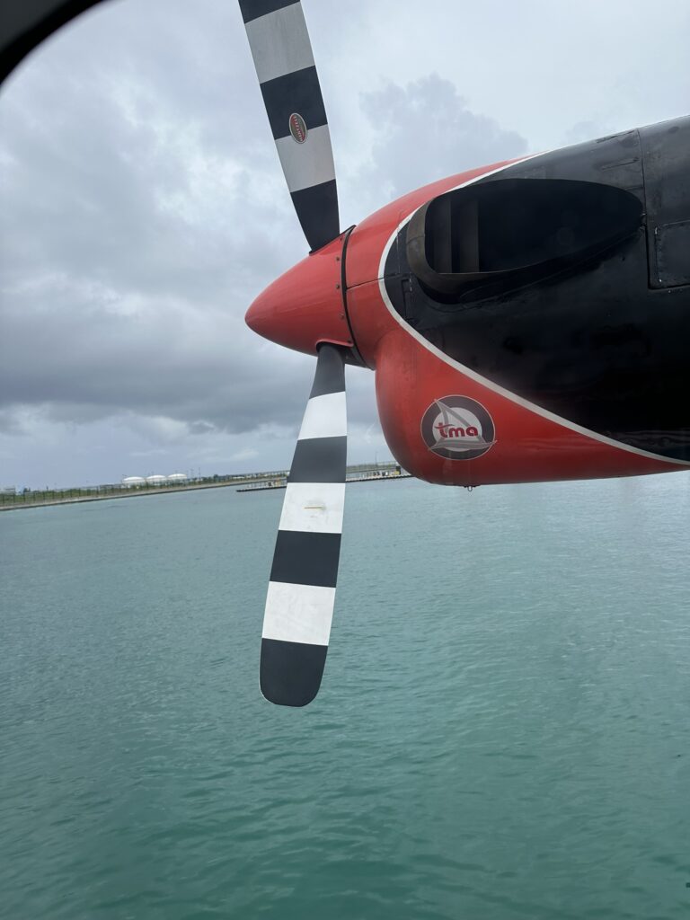 Looking out the window of the seaplane at the propeller on approach in the Maldives