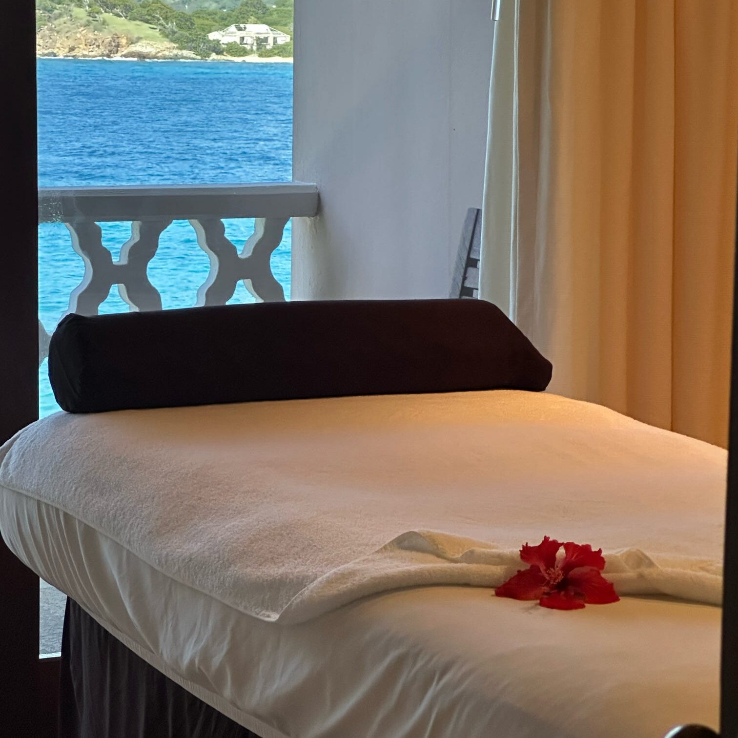 Massage table in a spa room with the view of the ocean out the window