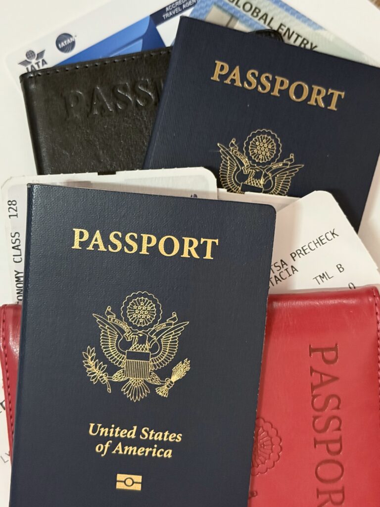 A pile of travel documents passports, boarding passes, global entry card